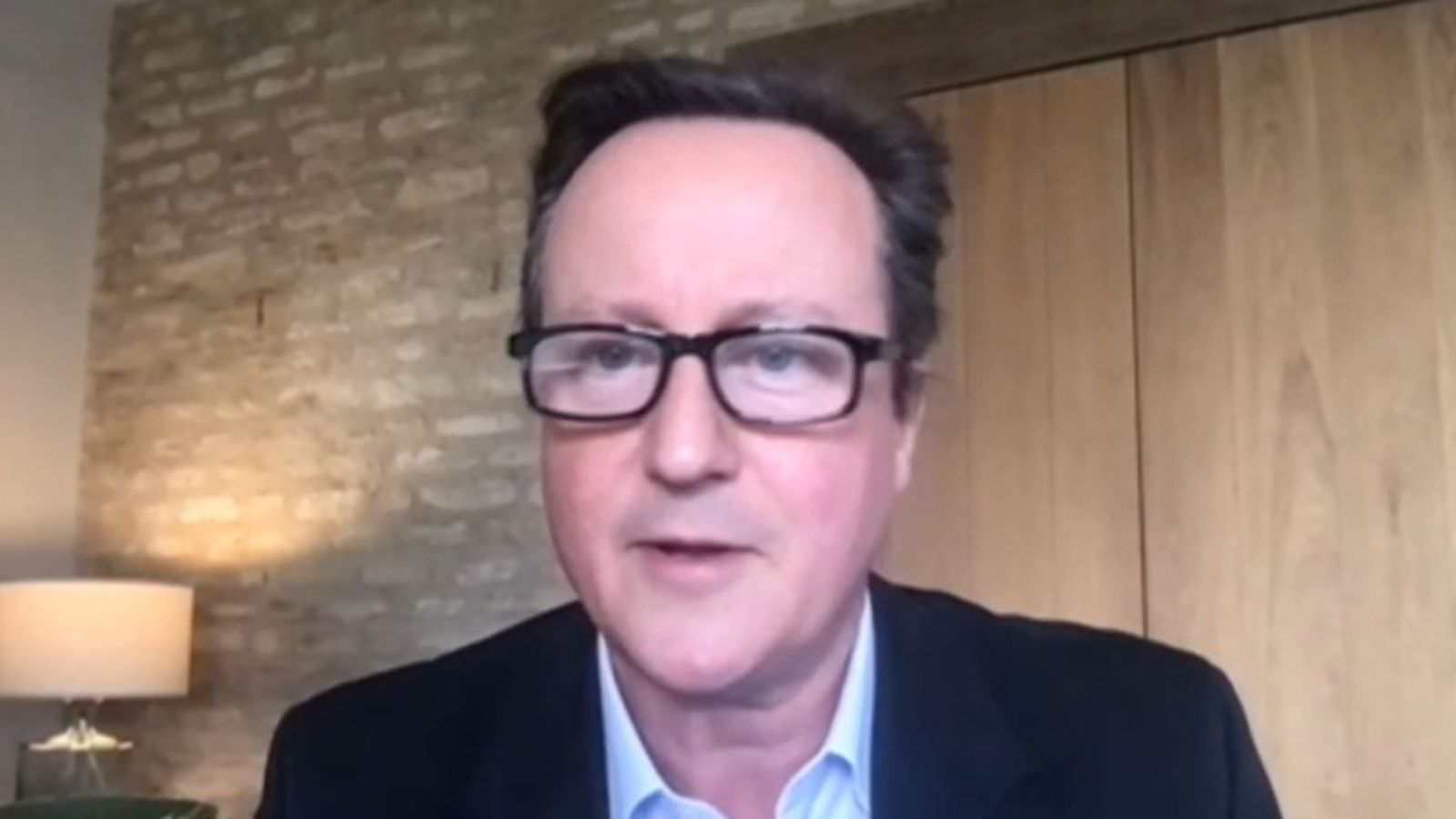戴维·卡梅伦（David Cameron）穿着西装和领带对着镜头微笑：卡梅伦先生正在与国家安全战略委员会成员讲话